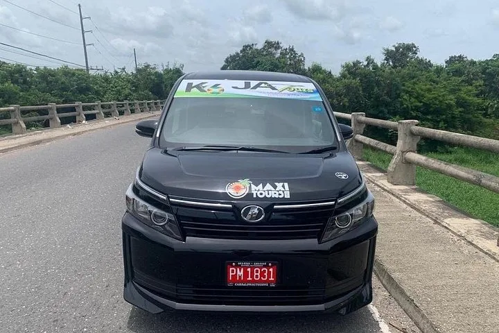 Schwarzer Minivan mit Logos von K JA Tours und Maxi Tours.